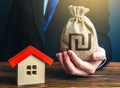 Man holds out a israeli shekel bag near the house. Home purchase, invest in real estate. Property appraisal. Favorable terms Royalty Free Stock Photo