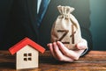 Man holds out a polish zloty bag near the house. Home purchase, invest in real estate. Property appraisal. Favorable terms and Royalty Free Stock Photo