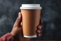 A man holds a paper cup for coffee in his hands, a mockup for manufacturers of branded cups for drinks. Royalty Free Stock Photo