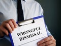 Man holds papers about Wrongful dismissal