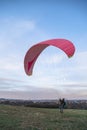 Man holds paraglider taking off in sky under wind