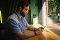 Man holds phone and chats online sitting in a cafe Royalty Free Stock Photo