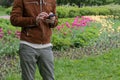 man holds a phone in a garden