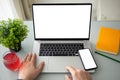 Man holds phone over laptop computer with isolated screen Royalty Free Stock Photo
