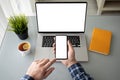Man holds phone over laptop computer with isolated screen Royalty Free Stock Photo