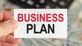 A man holds a piece of paper with the text: BUSINESS PLAN. Business and finance concept Royalty Free Stock Photo