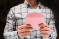 A man holds a pink envelope and reads a love letter Royalty Free Stock Photo