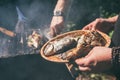 A man holds a plate with a ready meal. delicious and fresh grilled fish with lemon on the Barbeque grill at the garden Royalty Free Stock Photo