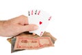 A man holds playing cards over a pile of cash Royalty Free Stock Photo