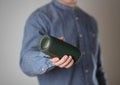 A man holds a portable speaker. Close up