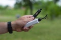 A man holds a power bank in his hands and charges an electronic cigarette against the backdrop of nature Royalty Free Stock Photo