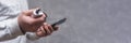 Man holds a power bank in his hands and charges a smartphone against a concrete wall Royalty Free Stock Photo