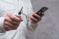 Man holds a power bank in his hands and charges a smartphone against a concrete wall Royalty Free Stock Photo