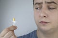 A man holds a rectal candle in his hand. A drug that is inserted into the rectum. Rectal suppository for hemorrhoids, constipation
