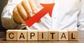 Man holds red arrow up above word Capital. Increase investment and foreign capital in the national economy. Improve business Royalty Free Stock Photo