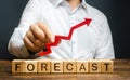 Man holds red arrow up over word Forecast. A budget surplus, prosperous economy or company. Prediction of profit growth, value Royalty Free Stock Photo