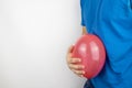 Bloating and flatulence concept. The man holds a red balloon near the abdomen, which symbolizes gas problems. Intestinal tract and