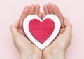 Man holds a red heart in his palms on a pink background Royalty Free Stock Photo