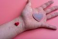 Man holds a red heart in his palms on a pink background Royalty Free Stock Photo