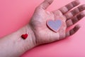 Man holds a red heart in his palms on a pink background Royalty Free Stock Photo