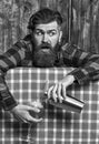 Man holds shaker on plaid tablecloth background.