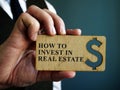 Man holds sign How to Invest in Real Estate