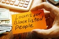 Man holds sign Loans for Blacklisted People