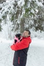 A man holds a small dog in his arms in a public park in winter. Positive emotions. Pets Royalty Free Stock Photo