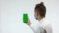 Man holds smarphone with green screen for copy space. Royalty Free Stock Photo