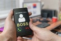 Man holds smartphone in hands with incoming call from boss