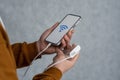 Man holds a smartphone and a portable charger in his hands on a gray background. Power Bank charges the phone. Cell Phone mockup