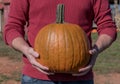 Man Holds Smooth Carving Pumpkin