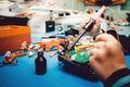 Man holds soldering iron, constructs automodels, solder schemes,