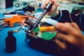 Man holds soldering iron, constructs automodels, solder schemes,