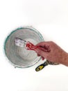 Man holds spatula against the background of old plastic bucket. Process of manual mixing construction putty.