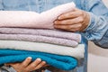 Man holds a stack of fresh terry towels. Organization and cleaning of the house. Storage and housekeeping concept