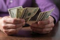 A man holds stack hundred-dollar bills in his hands close-up