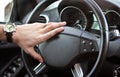 A man holds the steering wheel of a luxury car