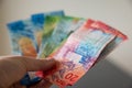 Man holds swiss banknotes in his hand and counts his monthly income. Royalty Free Stock Photo