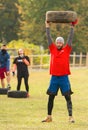 A man holds a tire over his head.