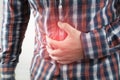 A man holds on to his stomach. Pain in the abdominal cavity. The concept of diseases of the stomach and digestive system
