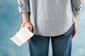 Man holds toilet paper on blue background