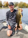 Fisherman Holding Trophy Largemouth Bass Fishing in Boat Royalty Free Stock Photo