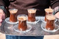 Man holds Turkish coffee on a metal tray