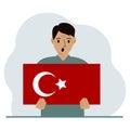 A man holds a Turkish flag in his hands. Concept for demonstration, national holiday, Turkey day or patriotism