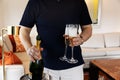 Man holds two glasses and a bottle of champagne standing in hotel room Royalty Free Stock Photo