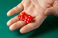 Man holds two red dices and throws them on green poker gaming table in casino. Concept of online gambling, winner or player Royalty Free Stock Photo