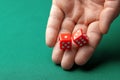 Man holds two red dices and throws them on green poker gaming table in casino. Concept of online gambling, winner or player Royalty Free Stock Photo