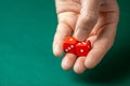 Man holds two red dices and throws them on green poker gaming table in casino. Concept of online gambling, winner or player Royalty Free Stock Photo