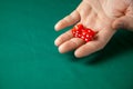 Man holds two red dices and throws them on green poker gaming table in casino. Concept of online gambling, winner or player Royalty Free Stock Photo